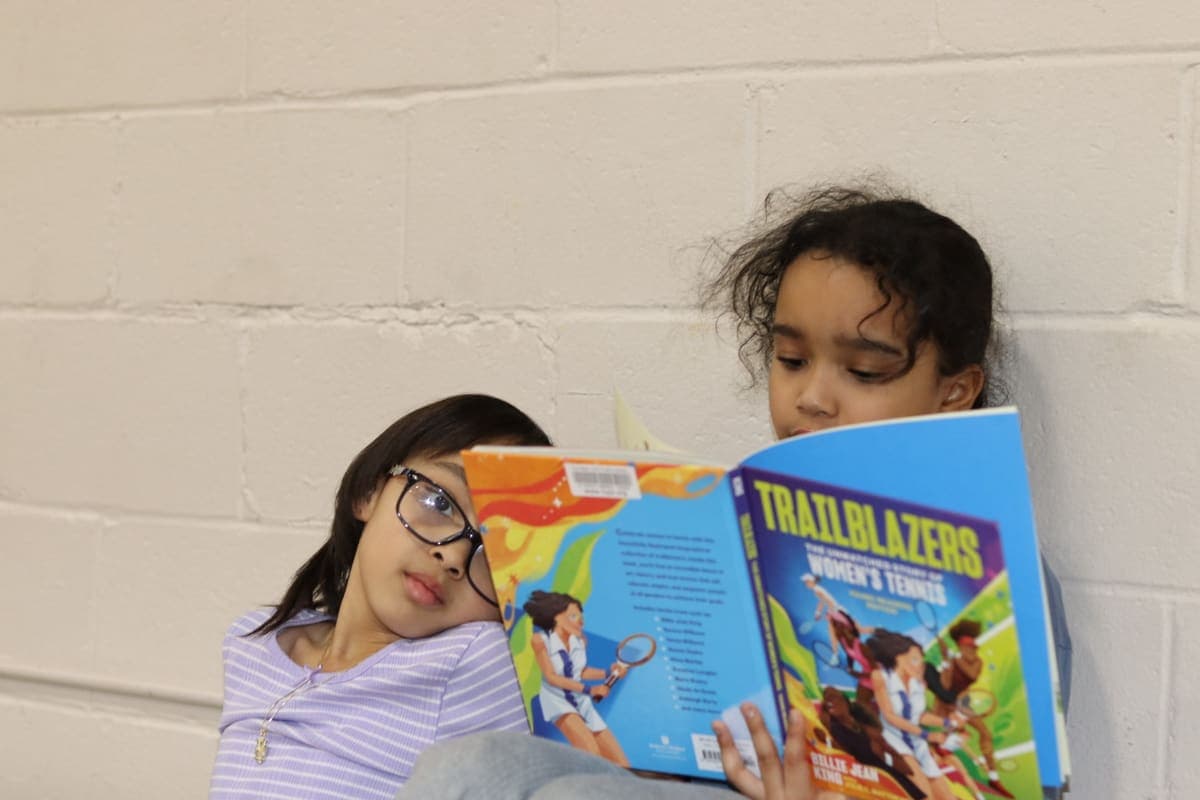 Two young readers sharing a book at a CLC program