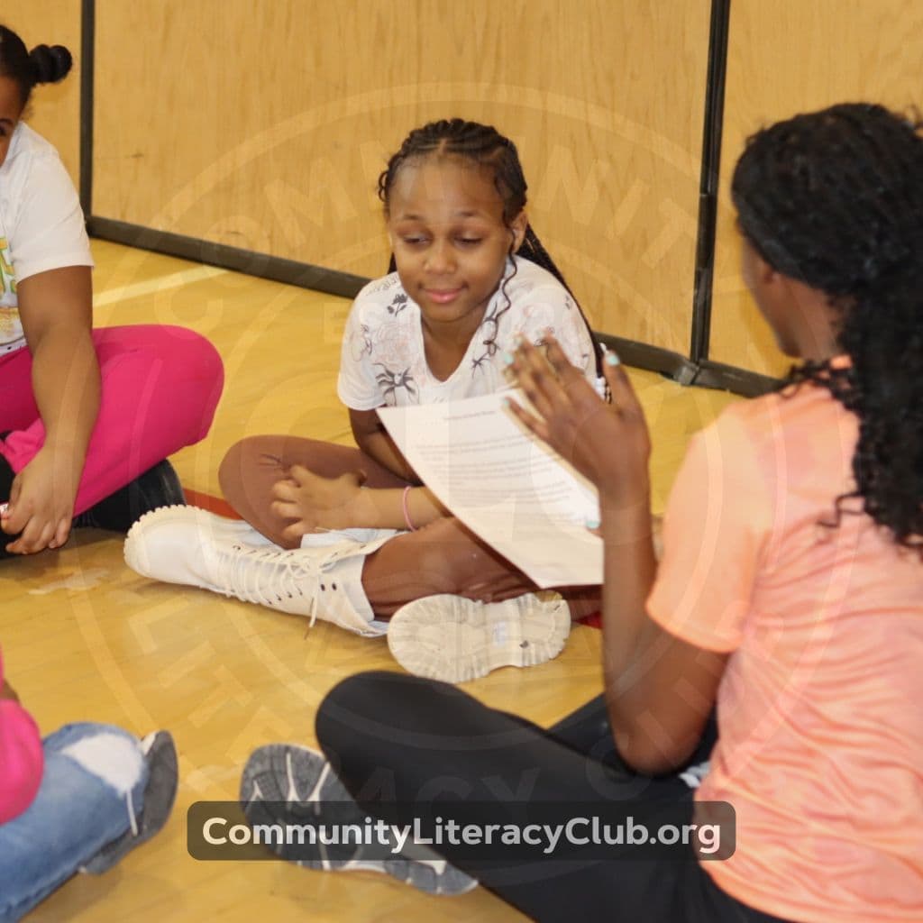 A student reading a printed story closely during a small-group session